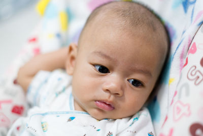 Portrait of cute baby lying on bed