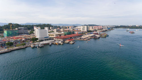 High angle view of buildings by sea against sky