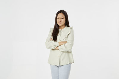 Portrait of a smiling young woman against white background