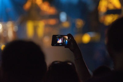 Cropped image of person photographing at night