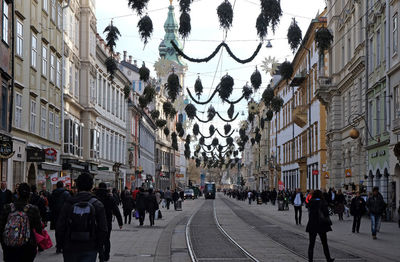 People walking on street amidst buildings in city