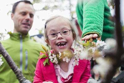 Portrait of happy handicapped girl with father and brother in yard