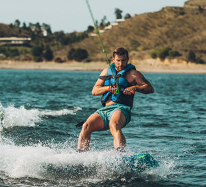 Full length of wakeboarding in sea