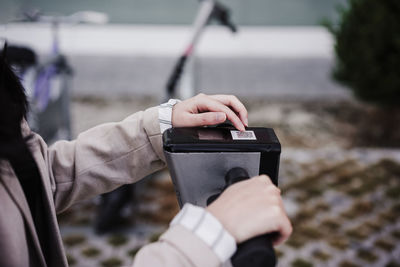 Close up of business woman renting electric scooter in city,wearing headphones.sustainable transport