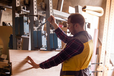 Side view of man working in factory