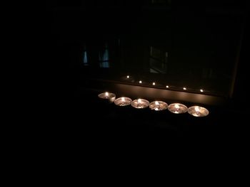 Illuminated candles in darkroom