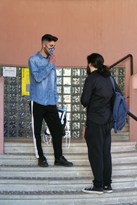 Full length of man standing against wall