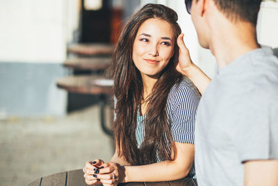 Beautiful woman looking at boyfriend at outdoor cafe