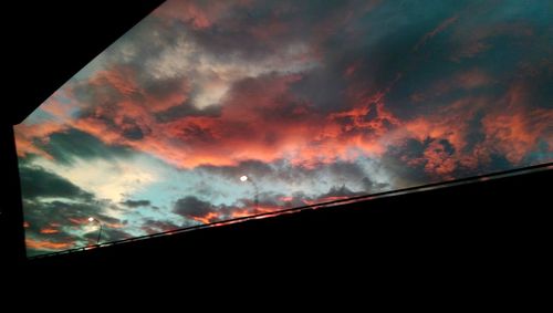 Low angle view of silhouette building against sunset sky