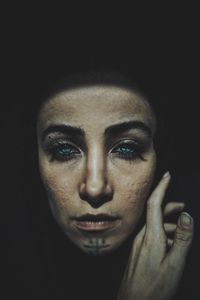 Close-up portrait of spooky woman on black background