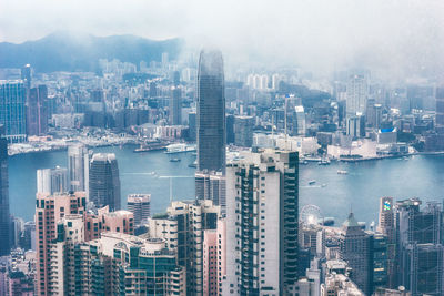 High angle view of city by sea against sky