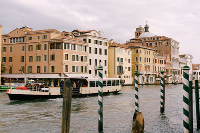 Boats in canal by buildings in city