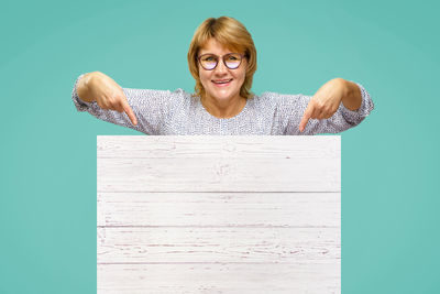 Portrait of smiling young woman against gray background