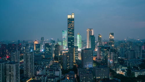 Illuminated cityscape against sky