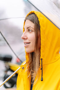 Smiling woman with umbrella standing in city