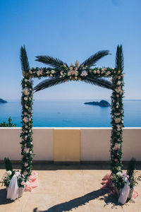 Plants by swimming pool against sea against clear sky