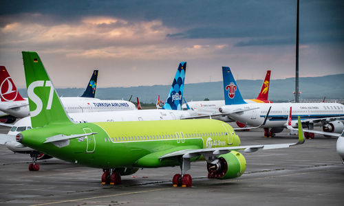 Airplane on airport runway against sky