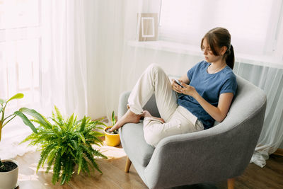 Young woman sitting on sofa at home