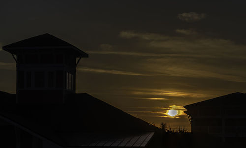 Low angle view of silhouette building against sky at sunset