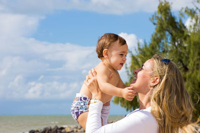 Mother and daughter against sky