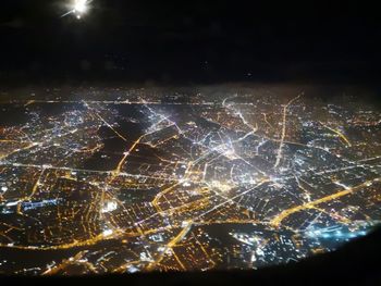 Aerial view of illuminated city against sky at night
