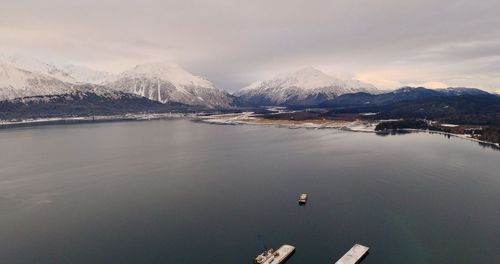 Scenic view of lake by snowcapped mountains against sky