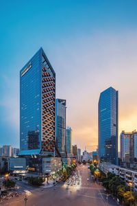 Modern buildings against sky at dusk