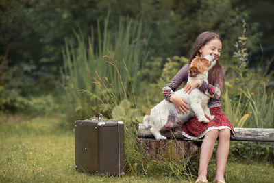 Woman with dog sitting on grass