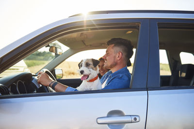 Couple with dog traveling in car