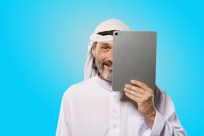 Digital composite image of businessman holding paper against blue background
