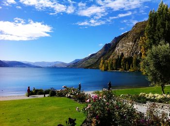 Scenic view of sea and mountains against blue sky