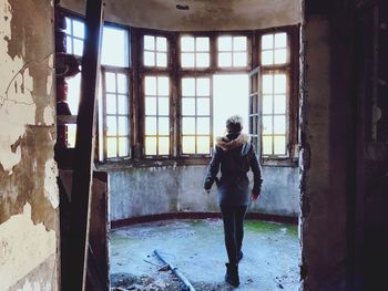 Young woman standing against window