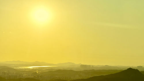 Scenic view of landscape against orange sky