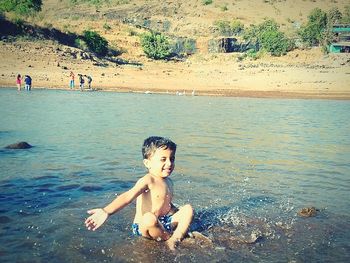 Full length of shirtless boy swimming in sea