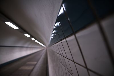 Close-up of tiled wall in illuminated tunnel