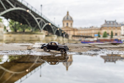 Reflection of bridge in puddle on river