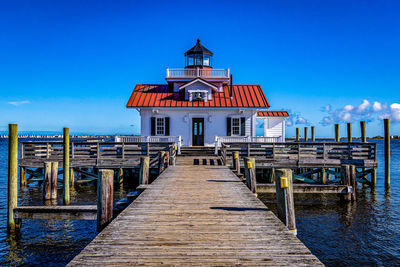 View of pier amidst buildings against sky