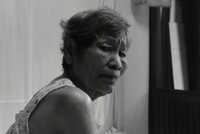 Side view portrait of wrinkled senior woman at home