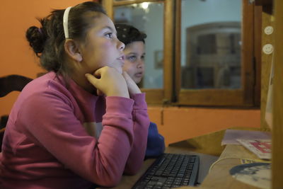 Siblings using computer at home