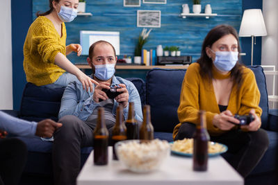 People wearing mask playing game at home