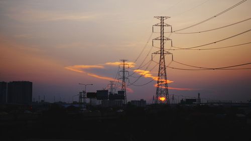 Silhouette of electricity pylon against sky during sunset