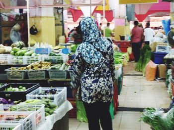 Rear view of woman standing at market stall