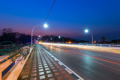 Light trails on road against sky at night