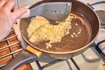 Midsection of person preparing food in kitchen at home