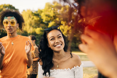 Cheerful young woman dancing with friends in music event