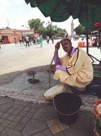 Woman sitting on sidewalk