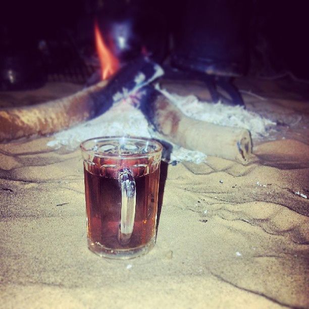 drink, food and drink, refreshment, drinking glass, close-up, heat - temperature, alcohol, freshness, flame, beach, sand, indoors, glass - material, sunlight, focus on foreground, burning, bottle, still life