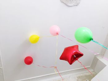 Close-up of multi colored balloons against white background