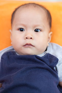 Close-up of toddler lying down on sofa at home