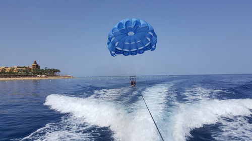 People parasailing over sea against sky